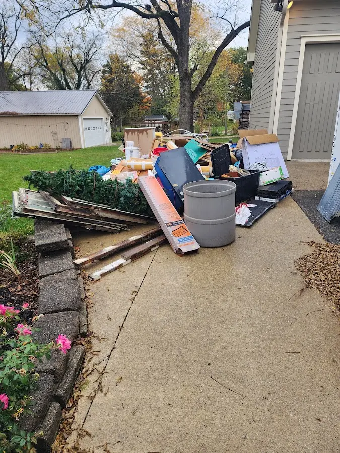 Dumpster being loaded with debris for 12 Yard Dumpster Rental in Farmington